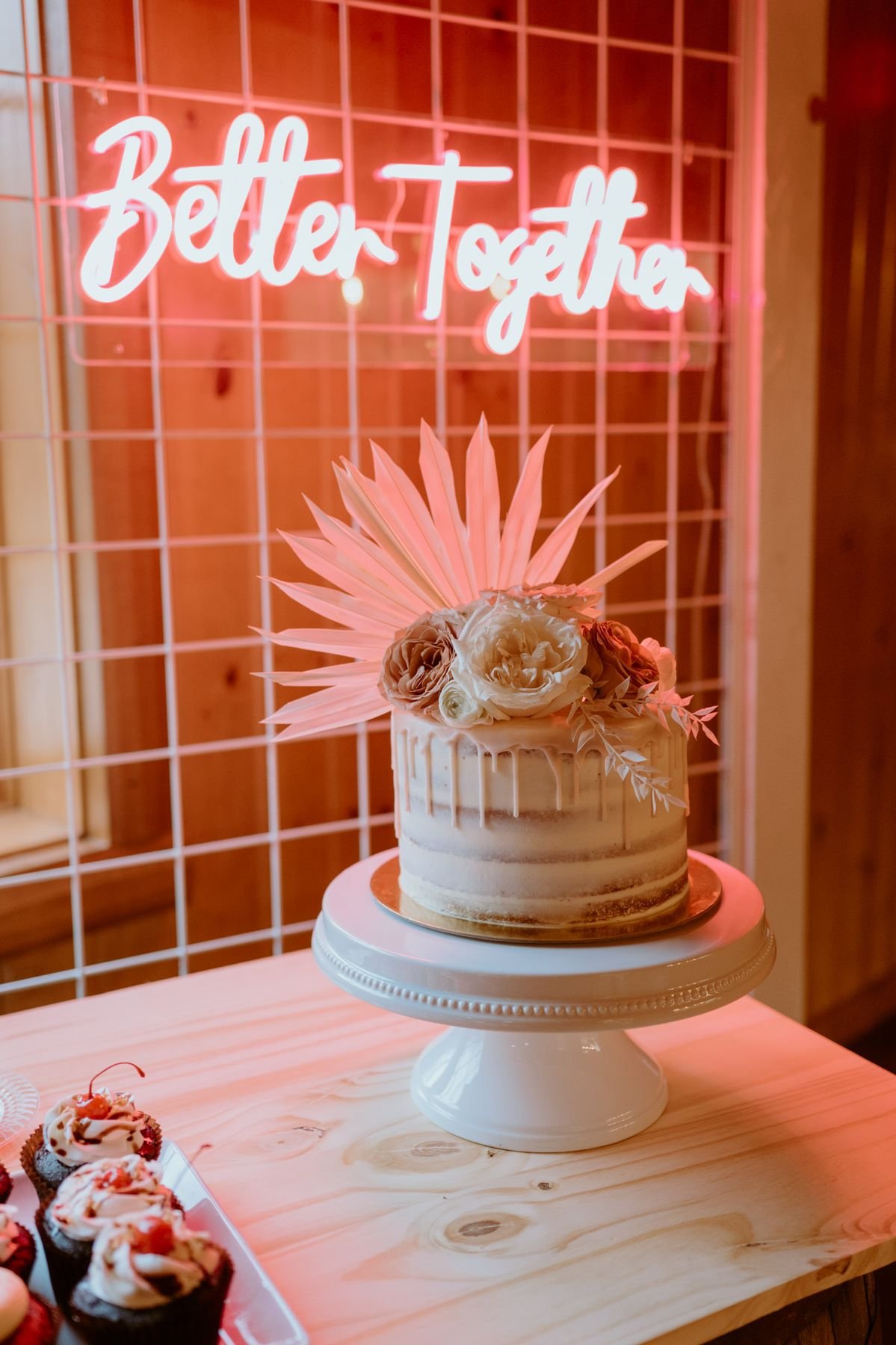 Bride and groom sharing a moment beside a glowing neon sign at their Indiana wedding reception
