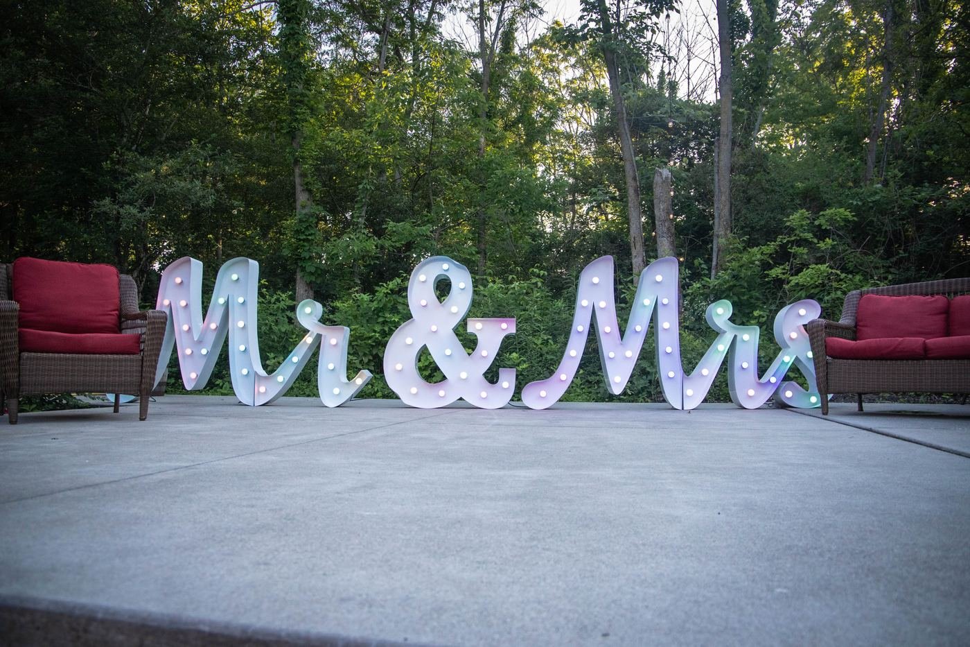 MR and MRS marquee letters staged with a red loveseat outdoors