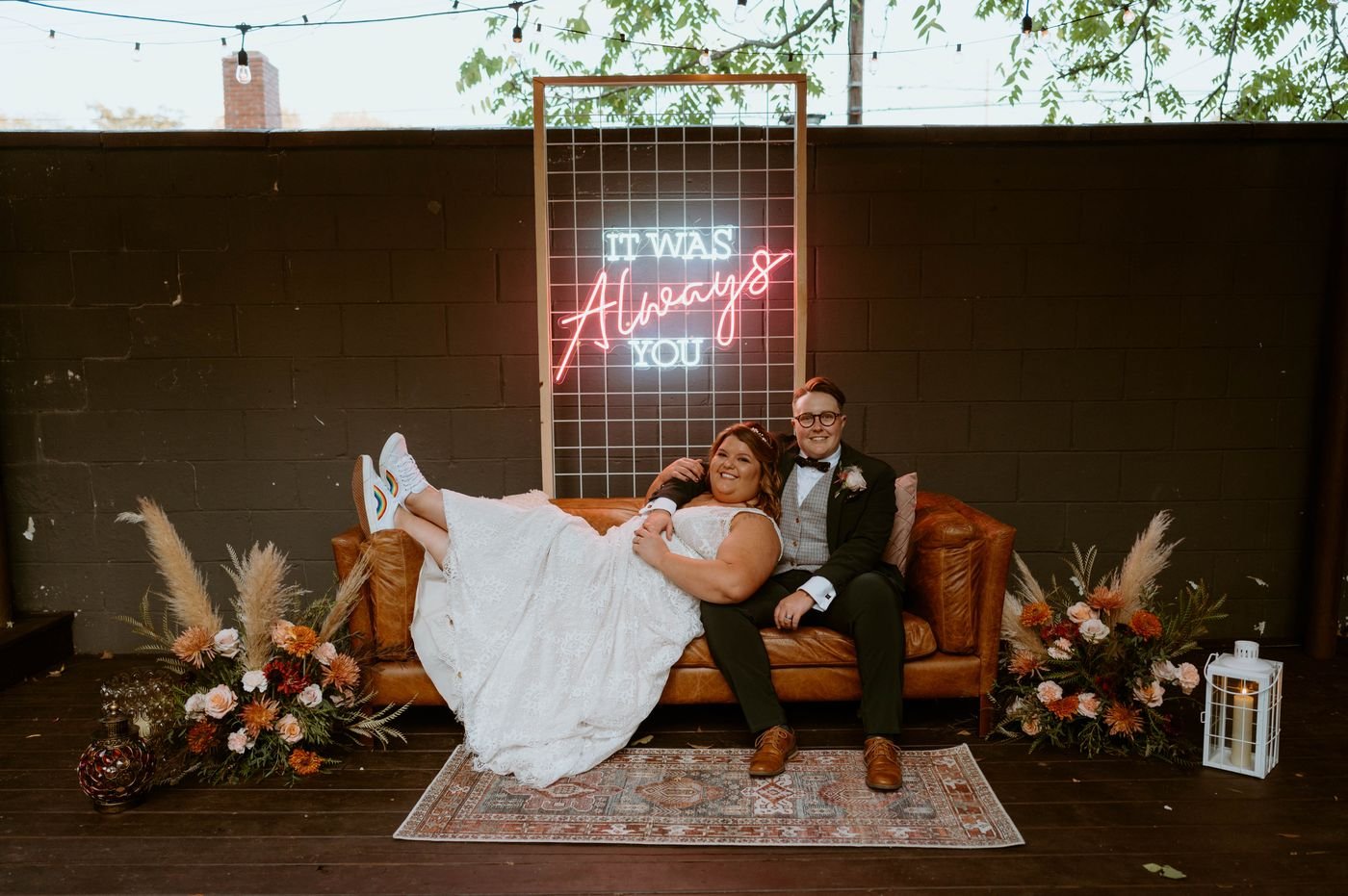 It Was Always You neon sign behind a couple holding hands